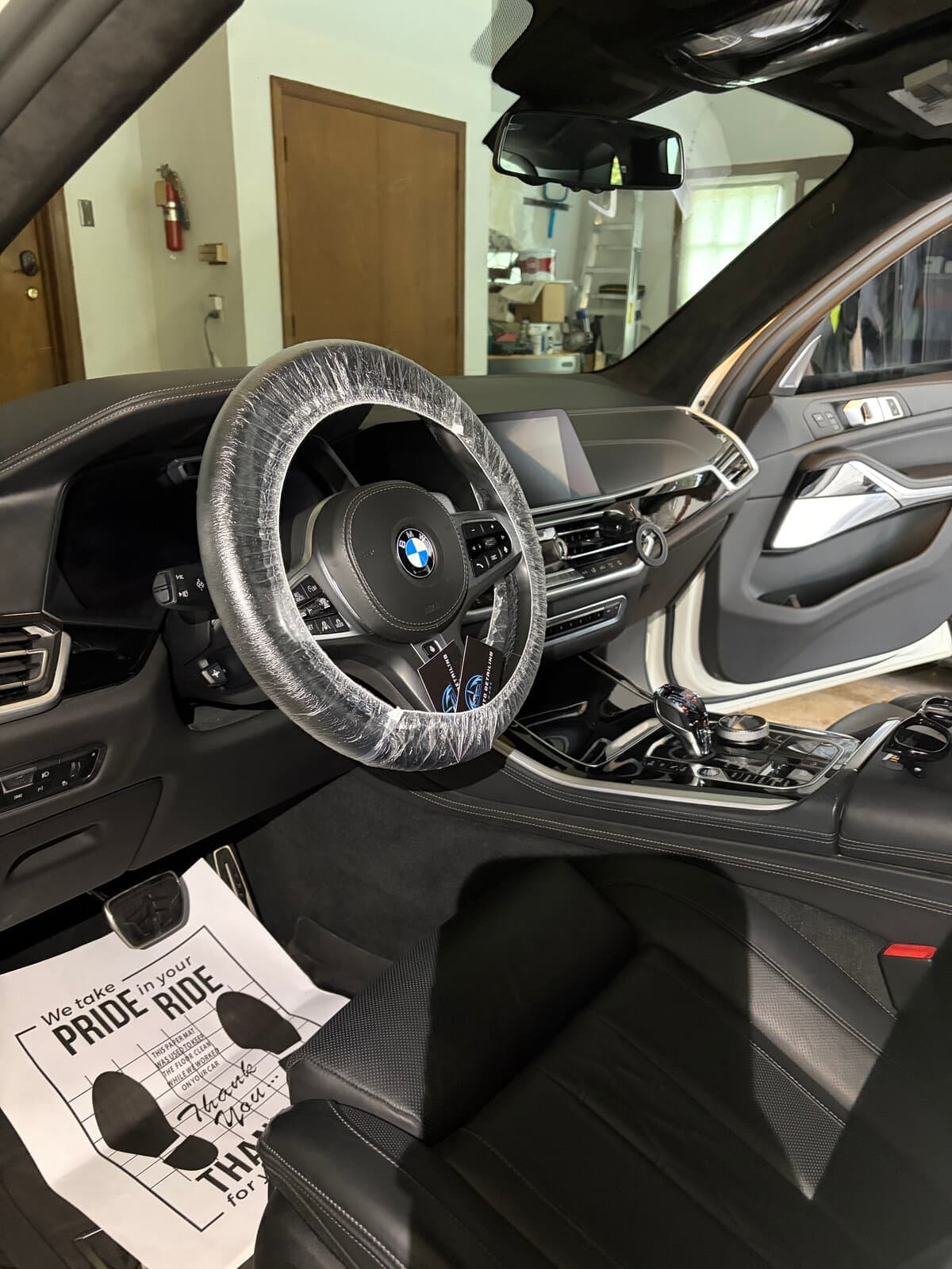 BMW black interior after a detail, with a paper floor mat